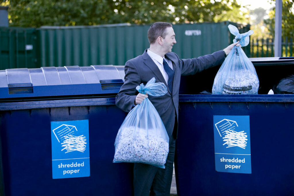 Biznesmen przy recyklingu dokumentów po zniszczeniu